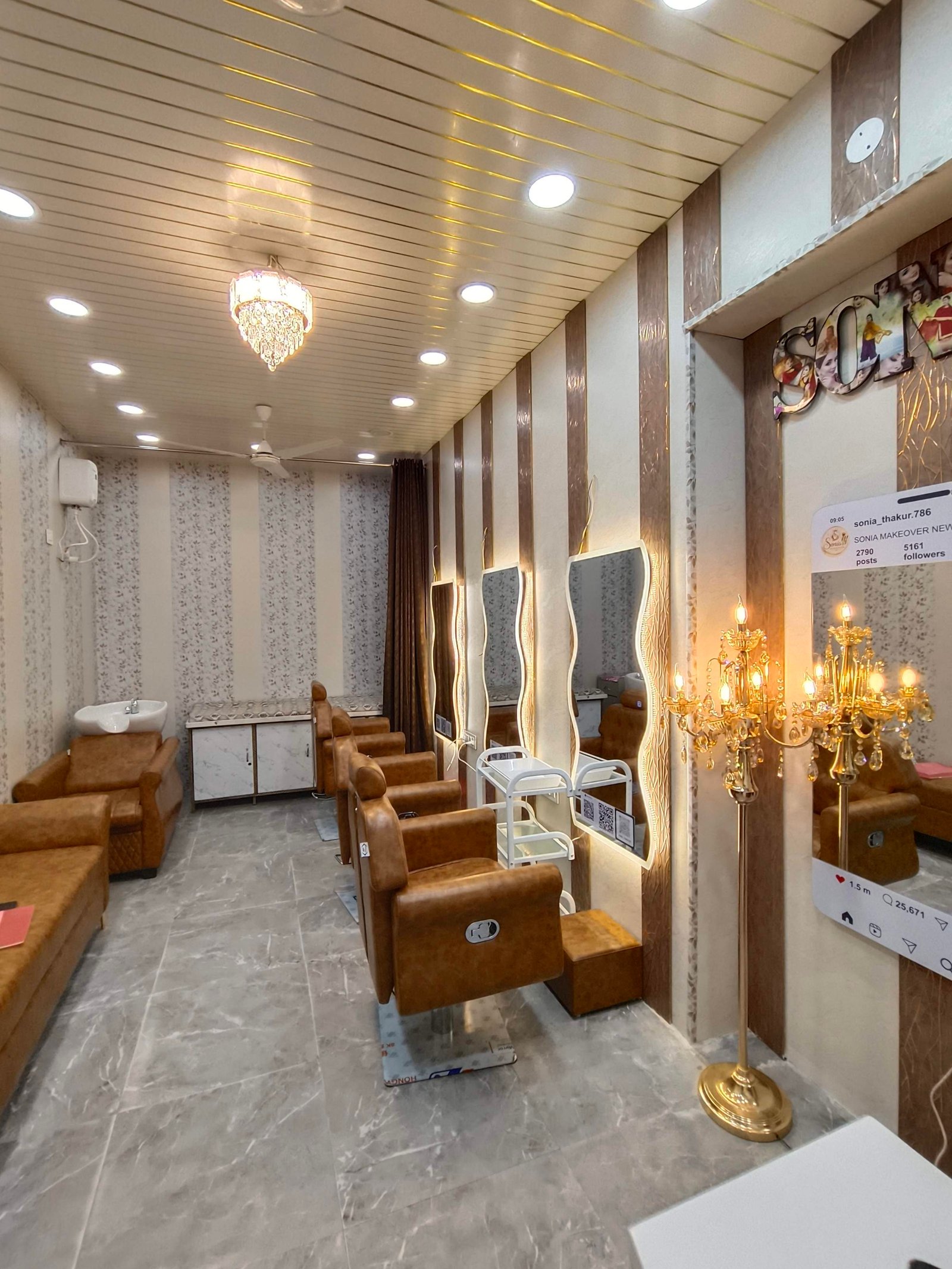 Hair salon interior with row of brown leather styling chairs at mirrors, marble floor, striped walls, and ornate chandelier lighting