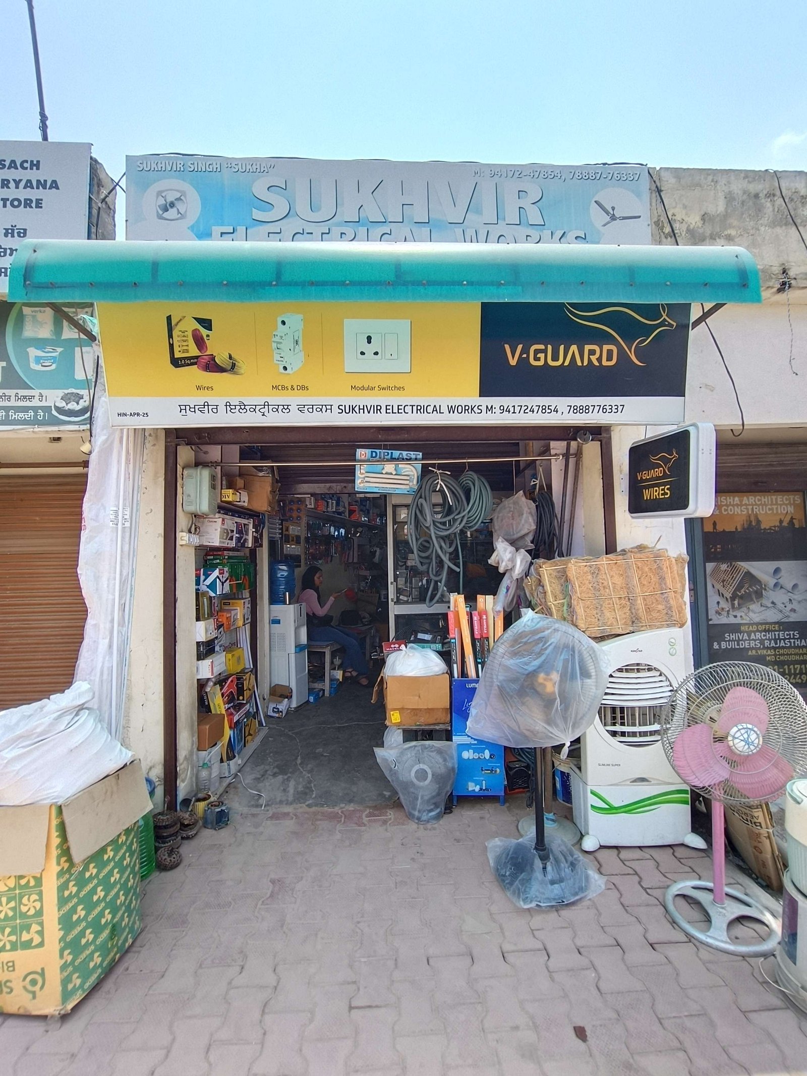 Open-front electrical shop selling wires, switches and electrical equipment with various products visible inside and outside.