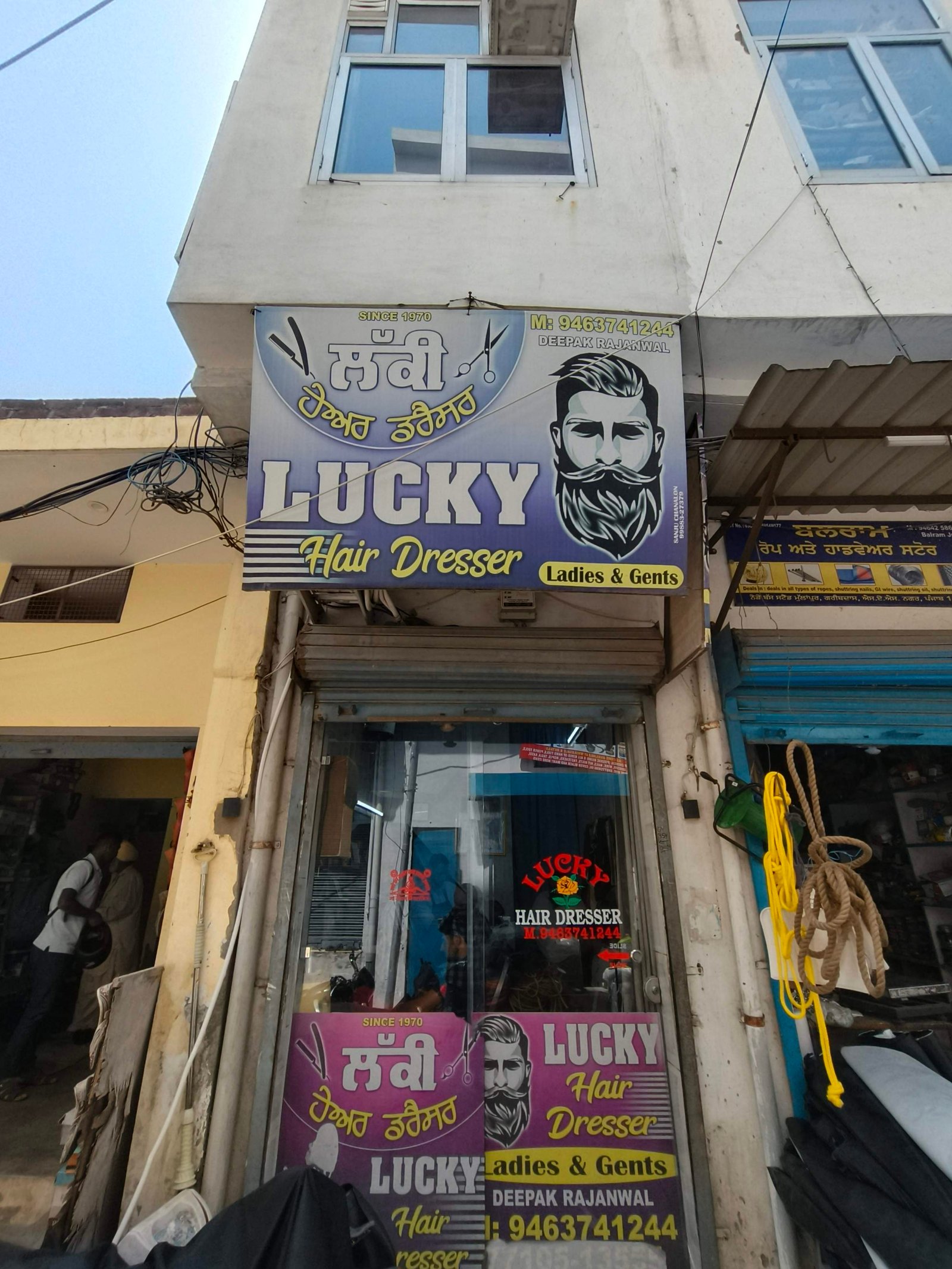 Shop sign reading 'LUCKY Hair Dresser' with a bearded portrait, advertising ladies and gents to passersby.